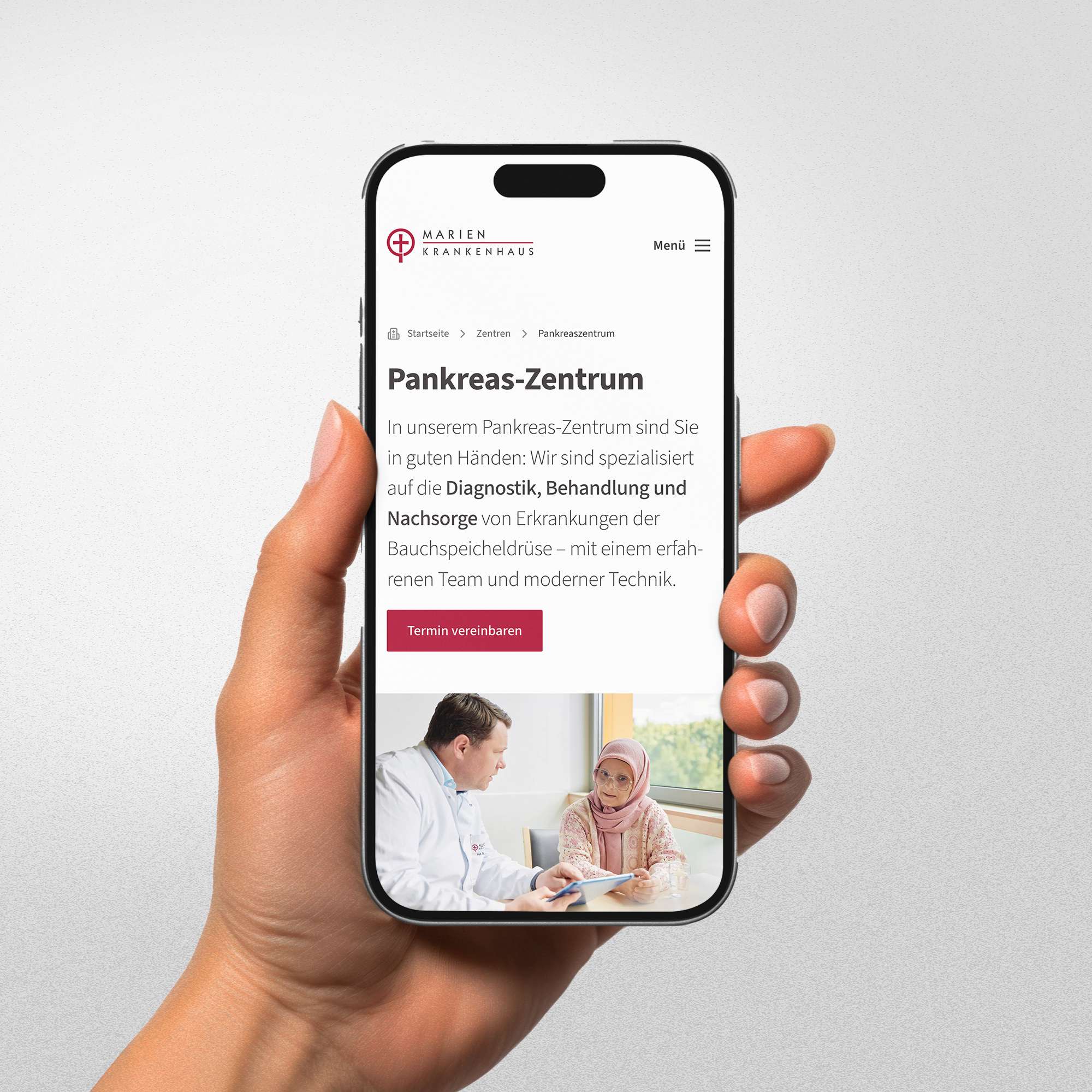 Weibliche Hand hält ein Smartphone, das eine Webseite des Pankreas-Zentrums zeigt.