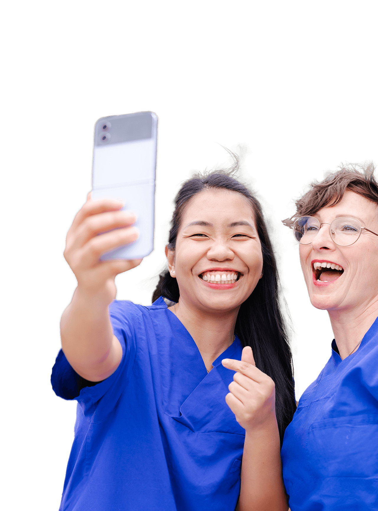 Zwei lachende Frauen in Kasak, die gerade ein Selfie von sich machen.